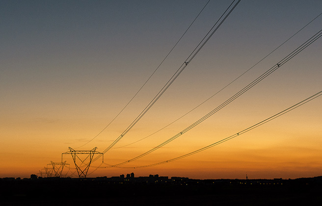 Sunset behind a row of power lines.