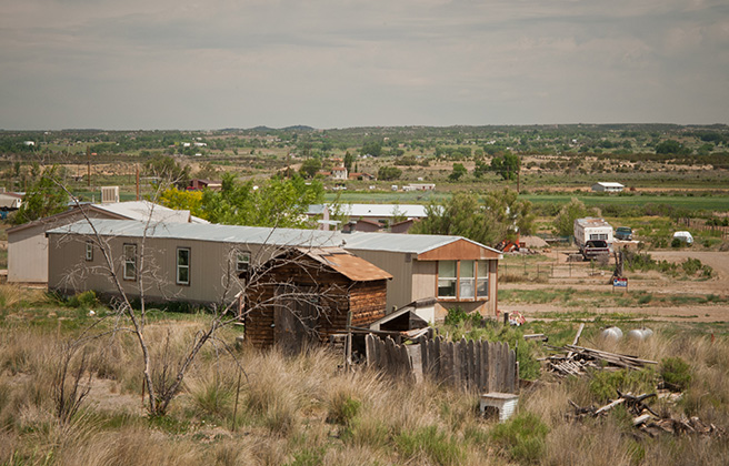 A rural town with small homes set far apart from one another in a flat landscape.