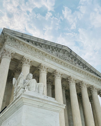 Close up of the Supreme Court of the United States building with Contemplation of Justice statue in foreground.