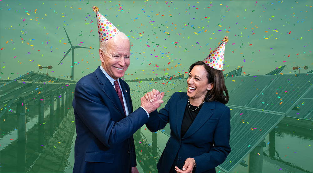 President Biden and Vice President Harris wearing party hats in front of a background of solar panels, wind turbines, and confetti.