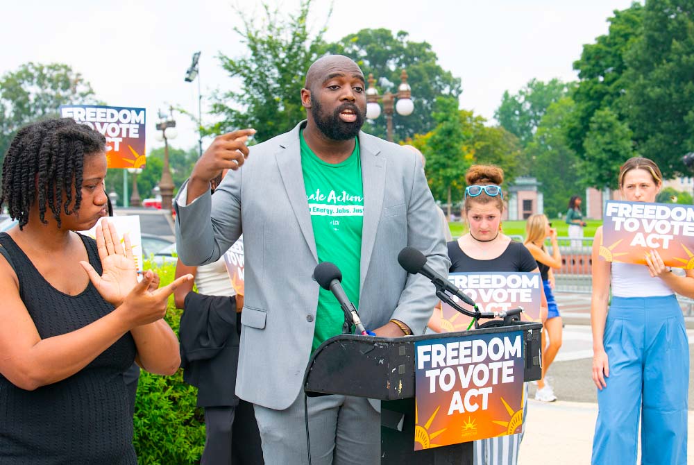 LCV staff member speaks at podium during a Freedom to Vote Act press conference outside the Capitol building