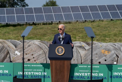 Biden stands at podium in front of solar panels at Vernon Electric Cooperative in Westby, Wisconsin